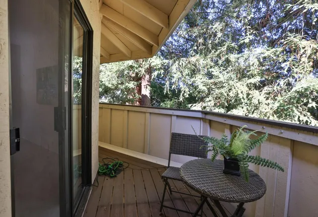a view of a balcony with chairs and wooden floor