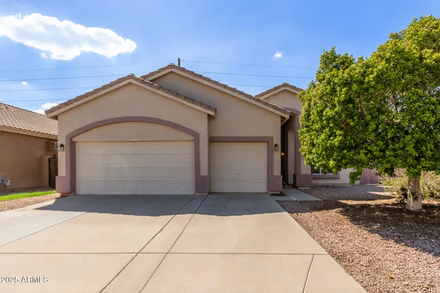 a view of a grey house with garage