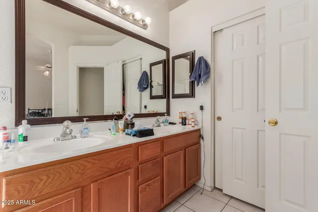 a bathroom with a double vanity sink a mirror a bathtub and next to a window