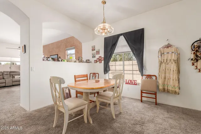 a dining room with furniture a chandelier and window