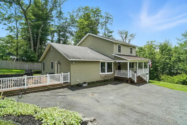 a view of a house with a yard and fence