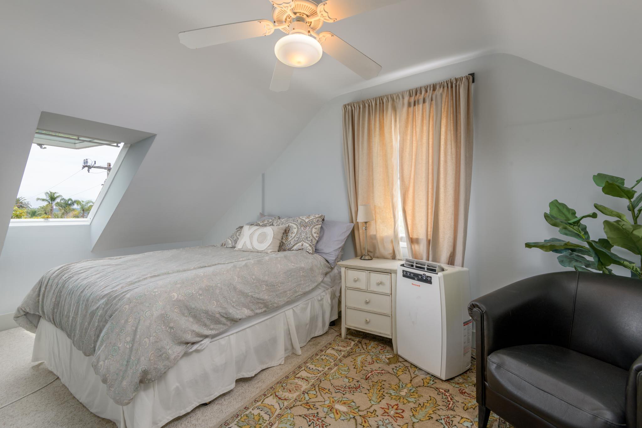 1833 Santa Barbara Street Santa Barbara, CA 93101 - Photo 21 of 35 a bedroom with a bed and a chandelier