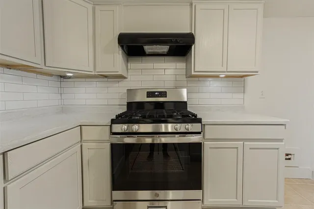 a stove top oven sitting inside of a kitchen