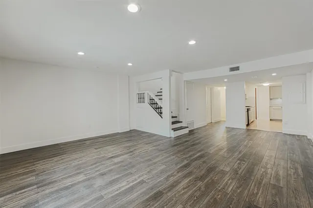 a view of an empty room with wooden floor