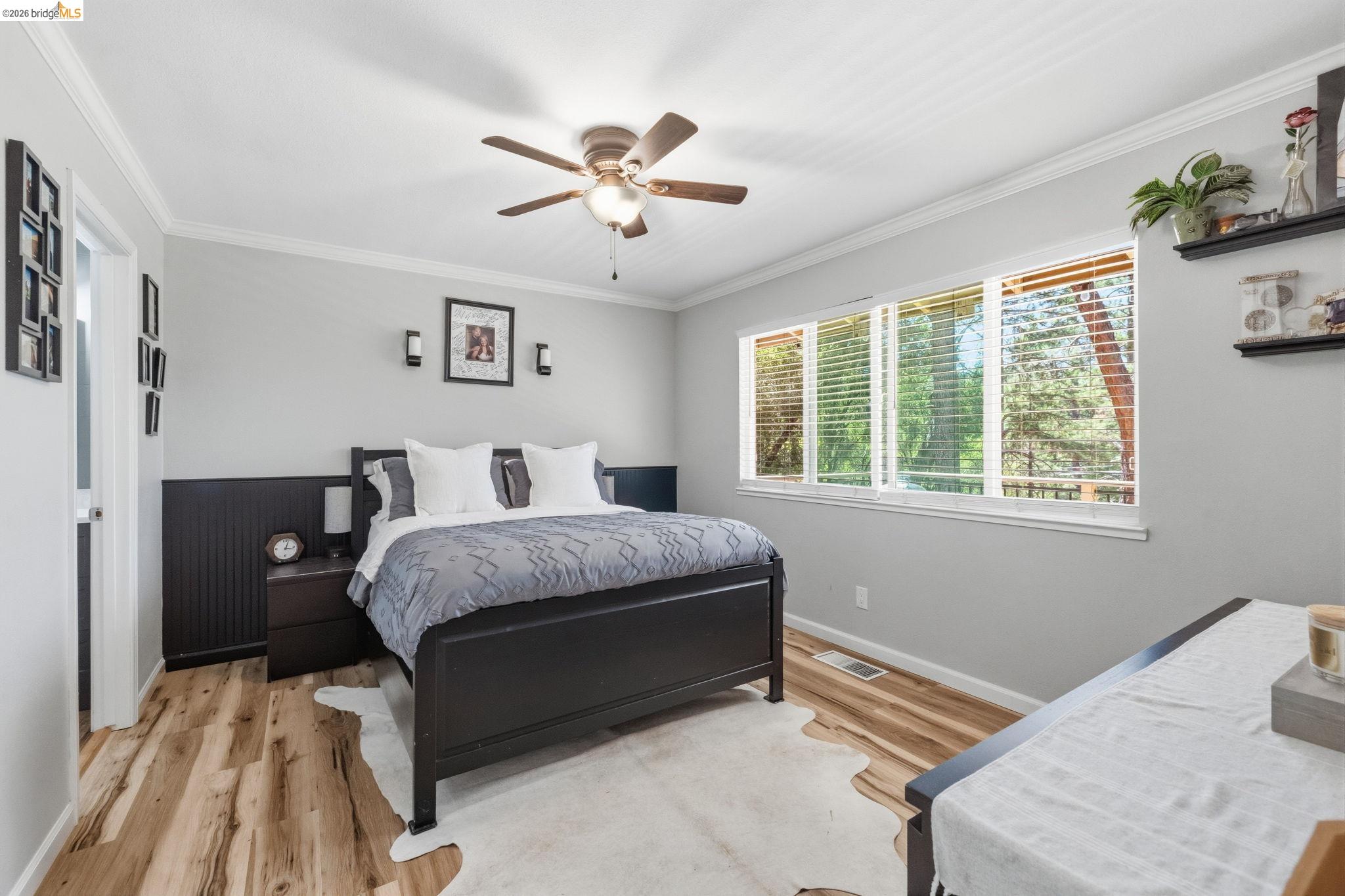 19059 Raboul Court Groveland, CA 95321 - Photo 11 of 21 Spacious interior featuring wood-finish flooring, a ceiling fan with integrated lighting, and multiple windows with horizontal blinds