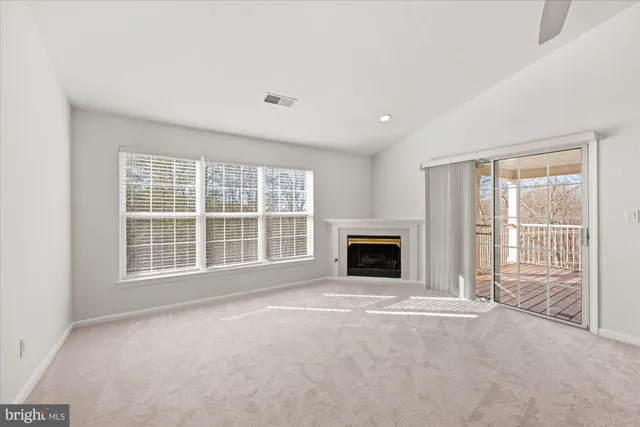 a view of an empty room with a fireplace and a window