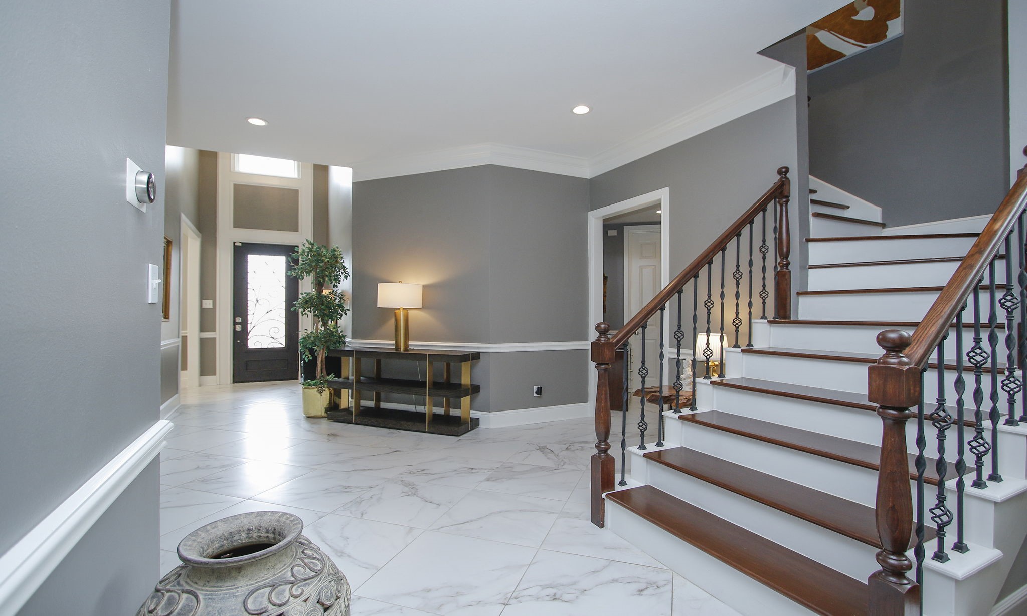 16610 Manningtree Lane Spring, TX 77379 - Photo 7 of 50 The stairs are located just off the entry featuring wood like stairs and iron railing.
