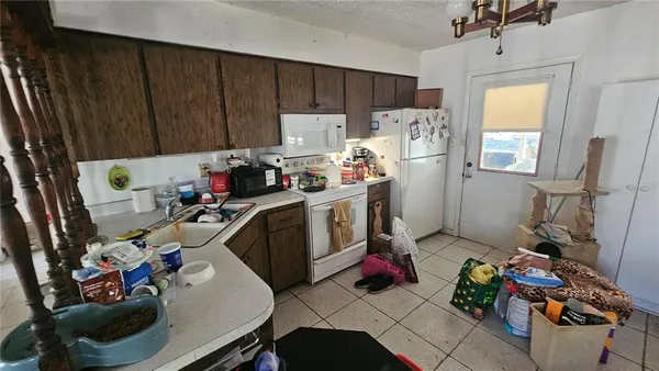 a view of a kitchen with fridge and workspace