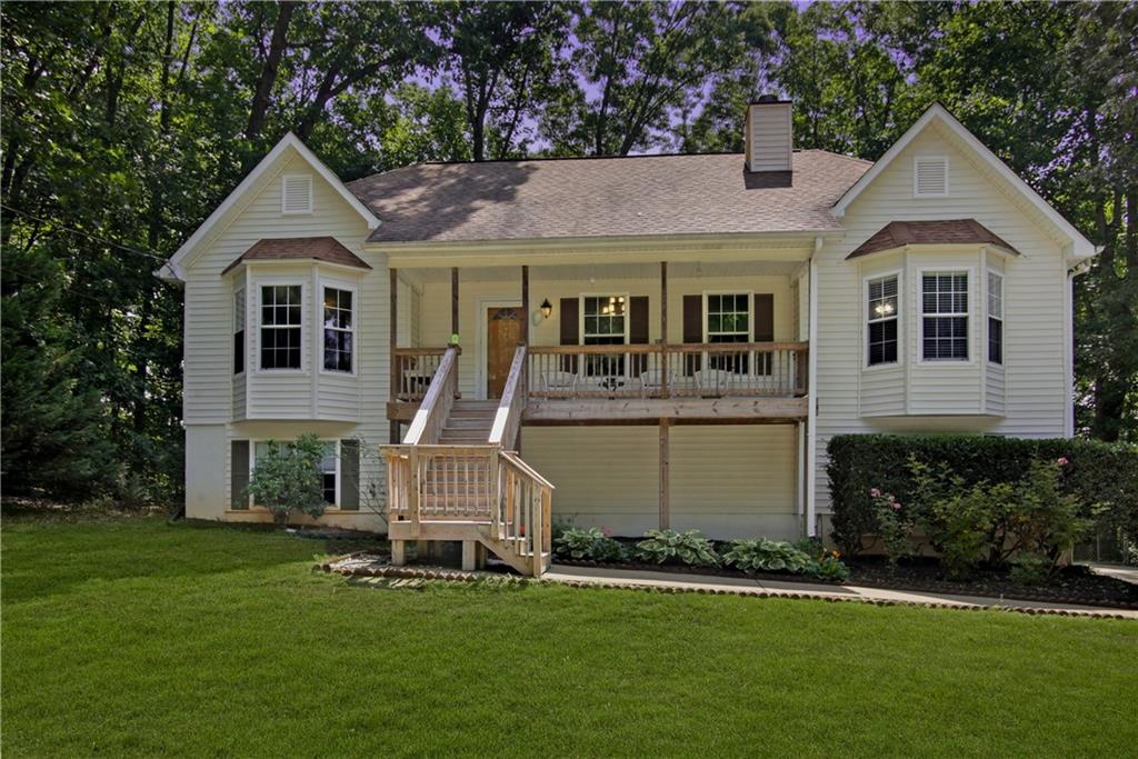 a front view of a house with a garden and trees