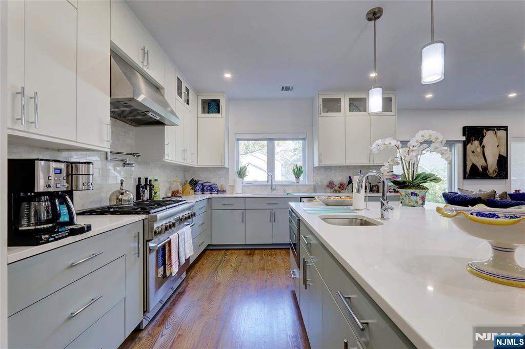 63 Sunset Lane Tenafly, NJ 07670 - Photo 11 of 20 a kitchen with a sink stove cabinets and wooden floor