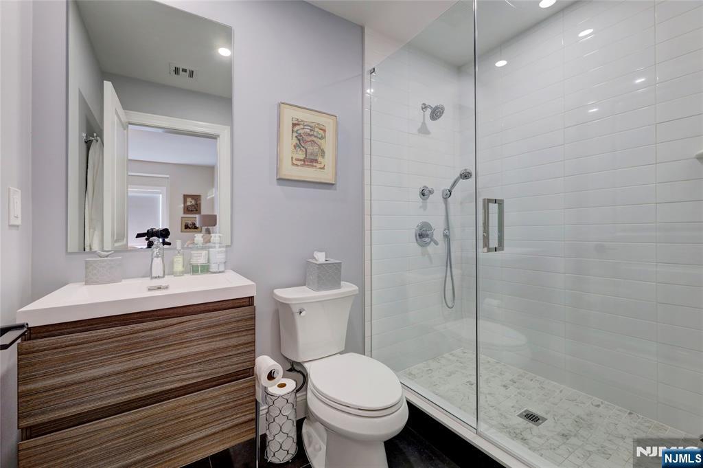 63 Sunset Lane Tenafly, NJ 07670 - Photo 13 of 20 a bathroom with a toilet a sink and shower
