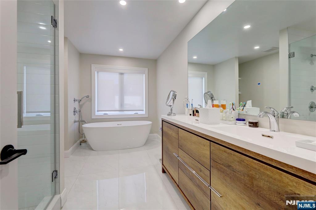 63 Sunset Lane Tenafly, NJ 07670 - Photo 19 of 20 a bathroom with a double vanity sink a mirror and bathtub