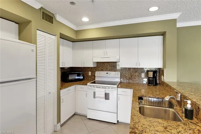 a kitchen with a sink a stove and cabinets