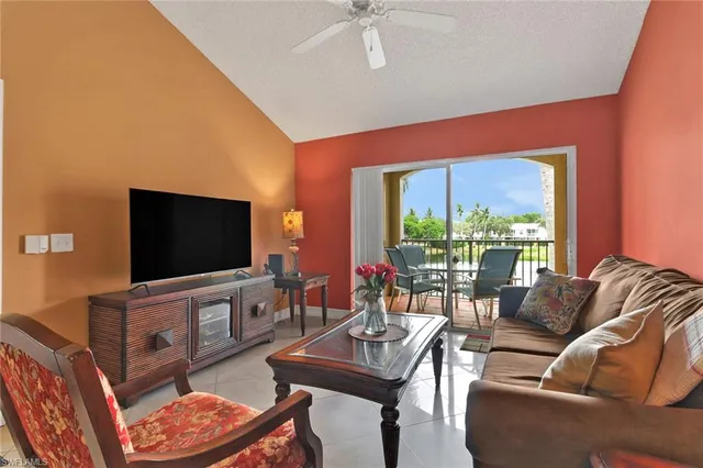 a living room with furniture a flat screen tv and a large window