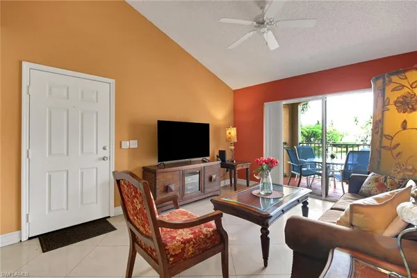 a living room with furniture a flat screen tv and a large window