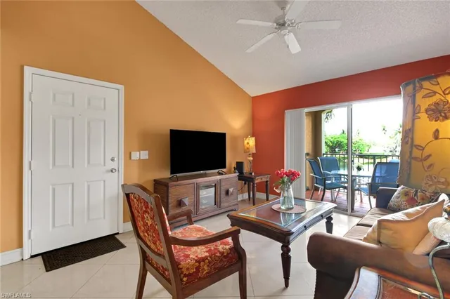 a living room with furniture a flat screen tv and a large window