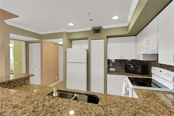 a kitchen with a refrigerator a sink and a stove top oven