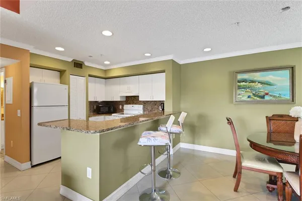 a living room with stainless steel appliances furniture a dining table and kitchen view