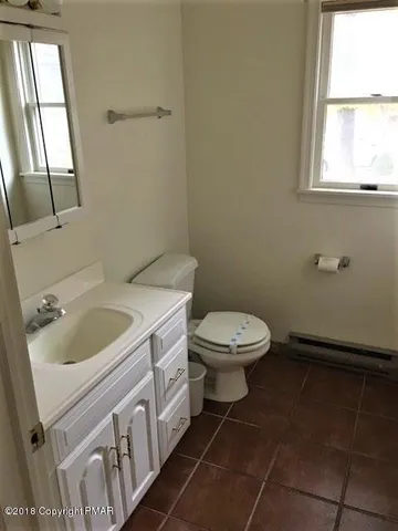 a bathroom with a sink toilet and window