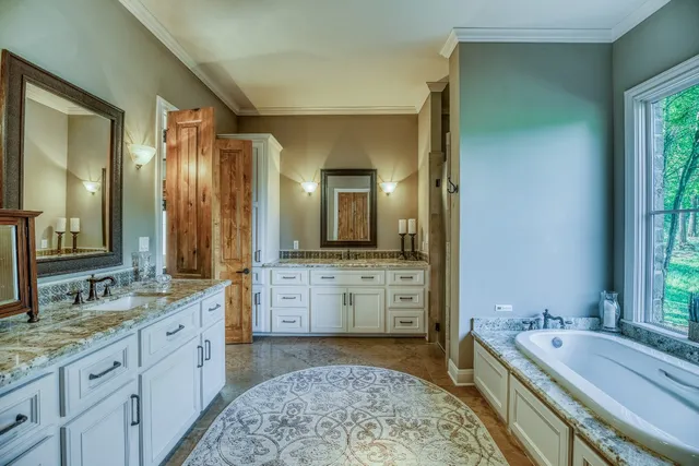 a spacious bathroom with a granite countertop tub sink and mirror