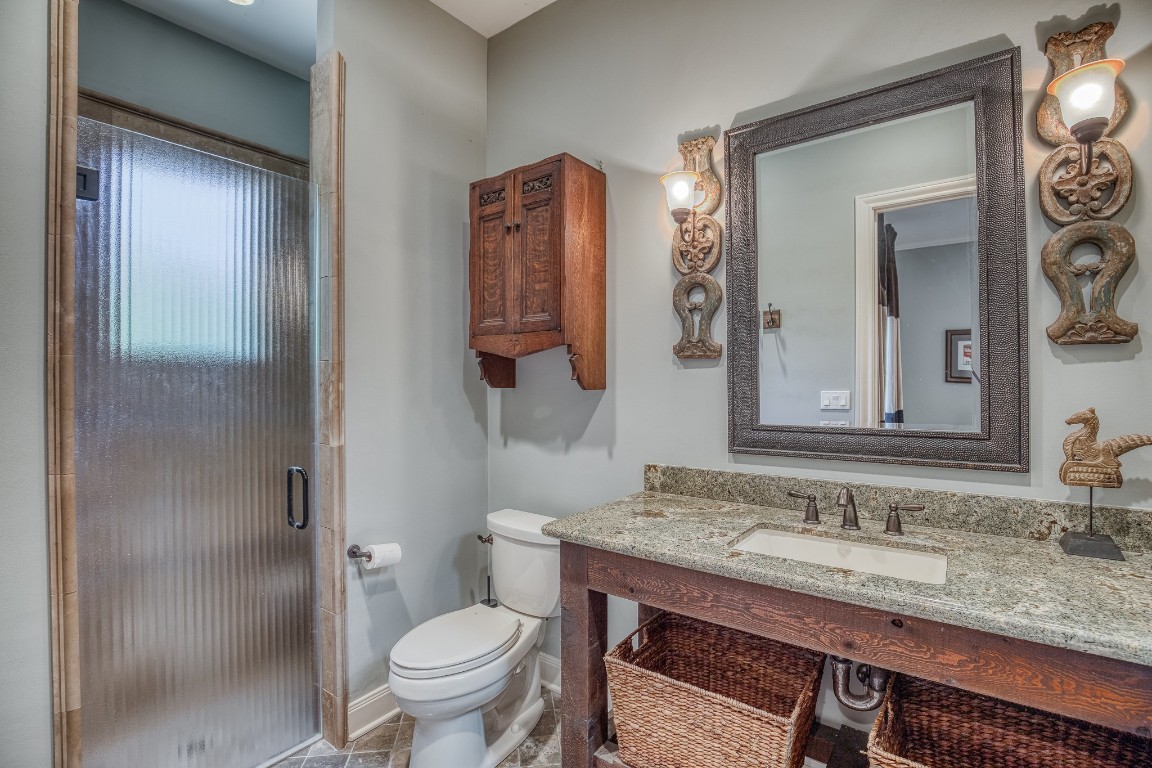 6925 South Sycamore Crossing Road Bellville, TX 77418 - Photo 19 of 40 a bathroom with a granite countertop toilet a sink and a mirror