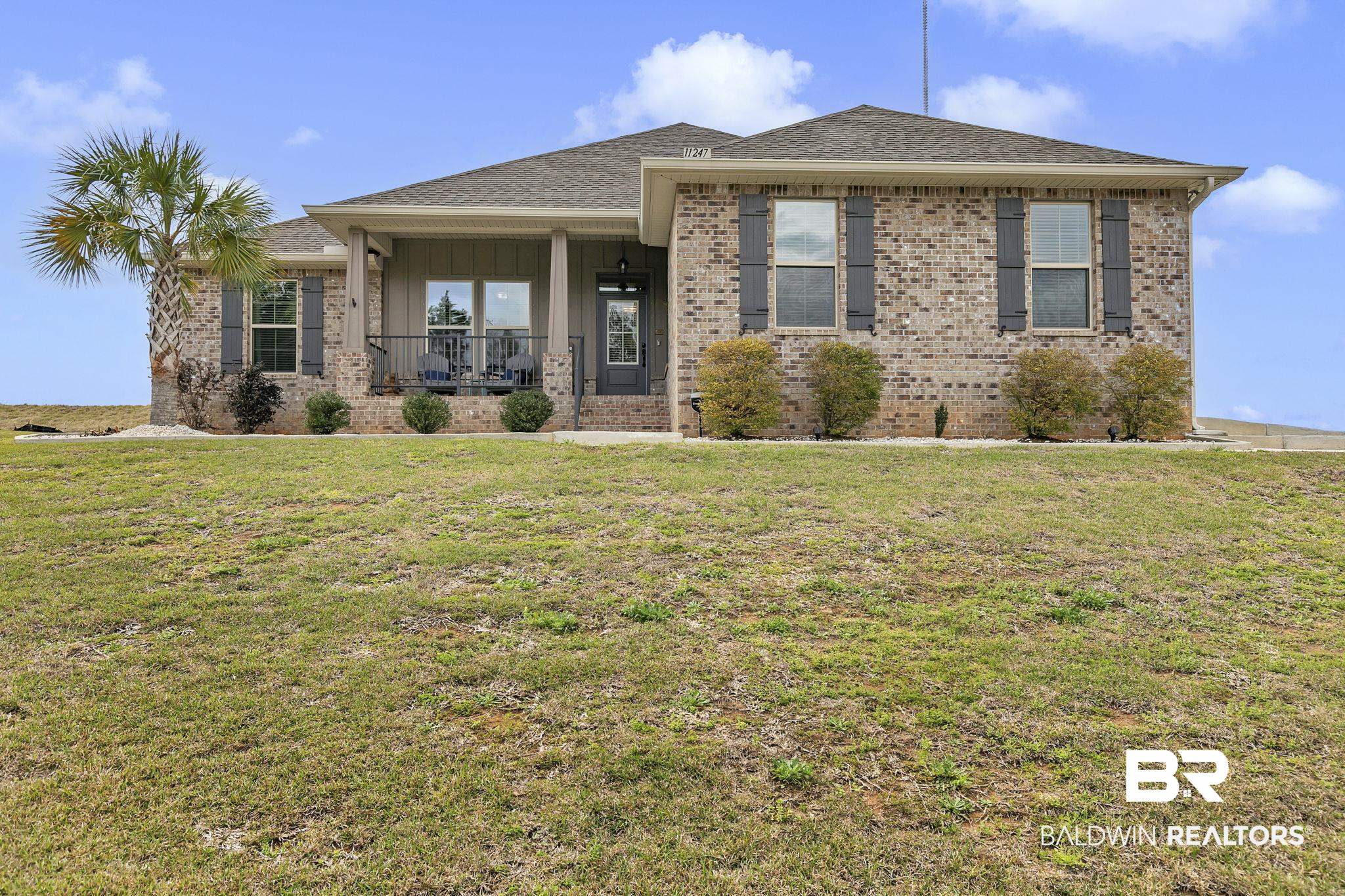 11247 Thistledown Loop Spanish Fort, AL 36527 - Photo 65 of 72 View of front of property featuring a porch, brick siding, board and batten siding, and a front lawn