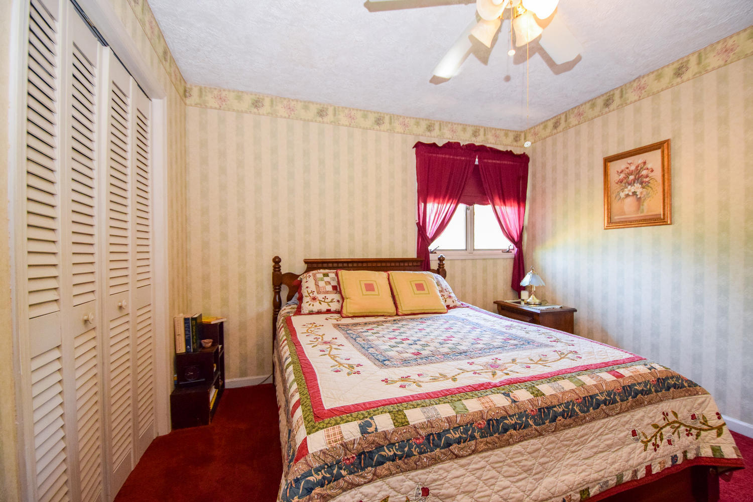 211 Rhododendron Road Callaway, VA 24067 - Photo 27 of 48 a bedroom with a bed and a chandelier