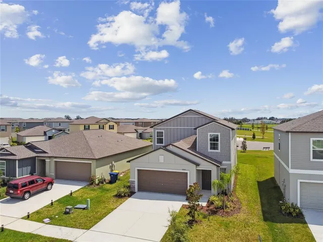 a view of a big house with a big yard and large tree