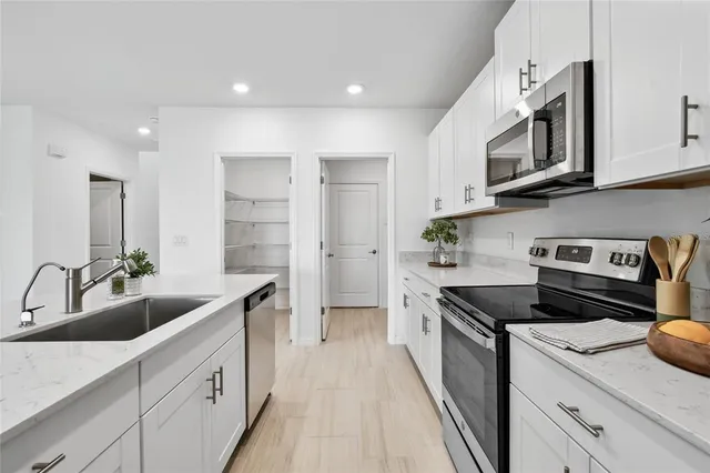 a kitchen with stainless steel appliances granite countertop a refrigerator and a stove top oven