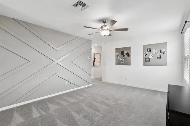 an empty room with window and ceiling fan