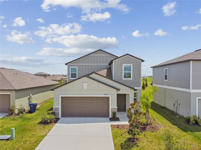 a front view of a house with a yard and garage