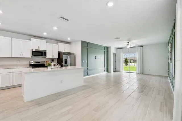 a kitchen with a sink and a large mirror
