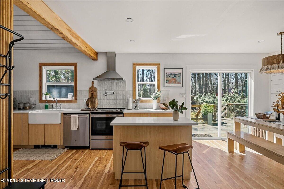 5306 Hummingbird Drive Pocono Summit, PA 18346 - Photo 11 of 32 a kitchen with stainless steel appliances granite countertop a stove top oven a sink dishwasher and white cabinets with wooden floor