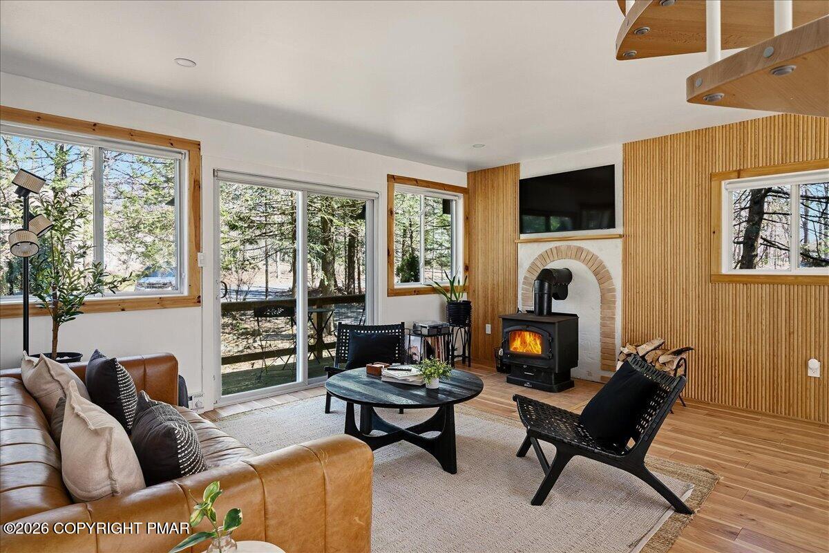 5306 Hummingbird Drive Pocono Summit, PA 18346 - Photo 6 of 32 a living room with furniture a fireplace and a large window