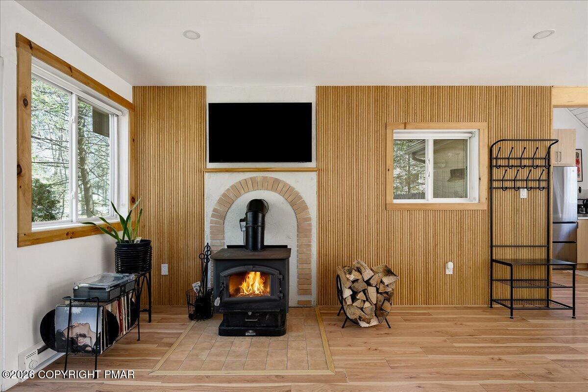 5306 Hummingbird Drive Pocono Summit, PA 18346 - Photo 7 of 32 a living room with furniture a flat screen tv and a fireplace