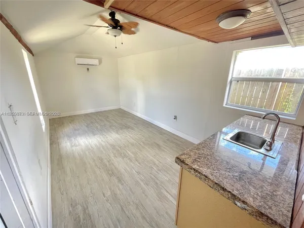 a kitchen with granite countertop a sink window and refrigerator
