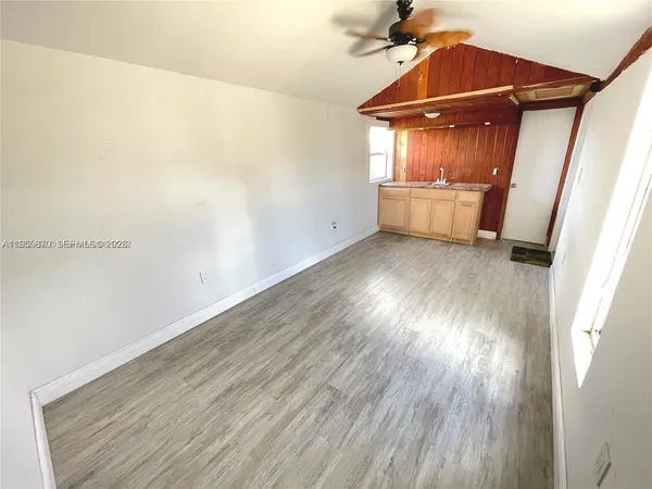a view of empty room with wooden floor
