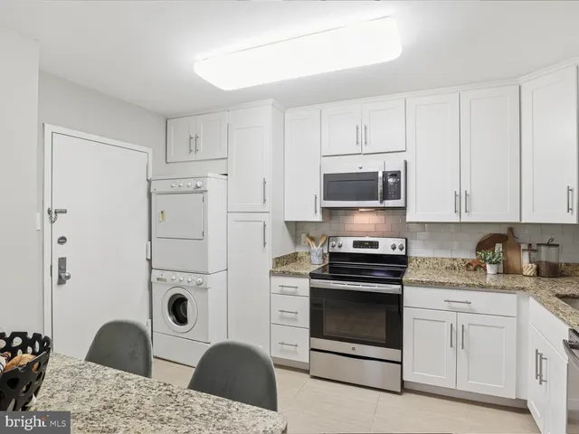 a kitchen with granite countertop a stove a sink and a microwave
