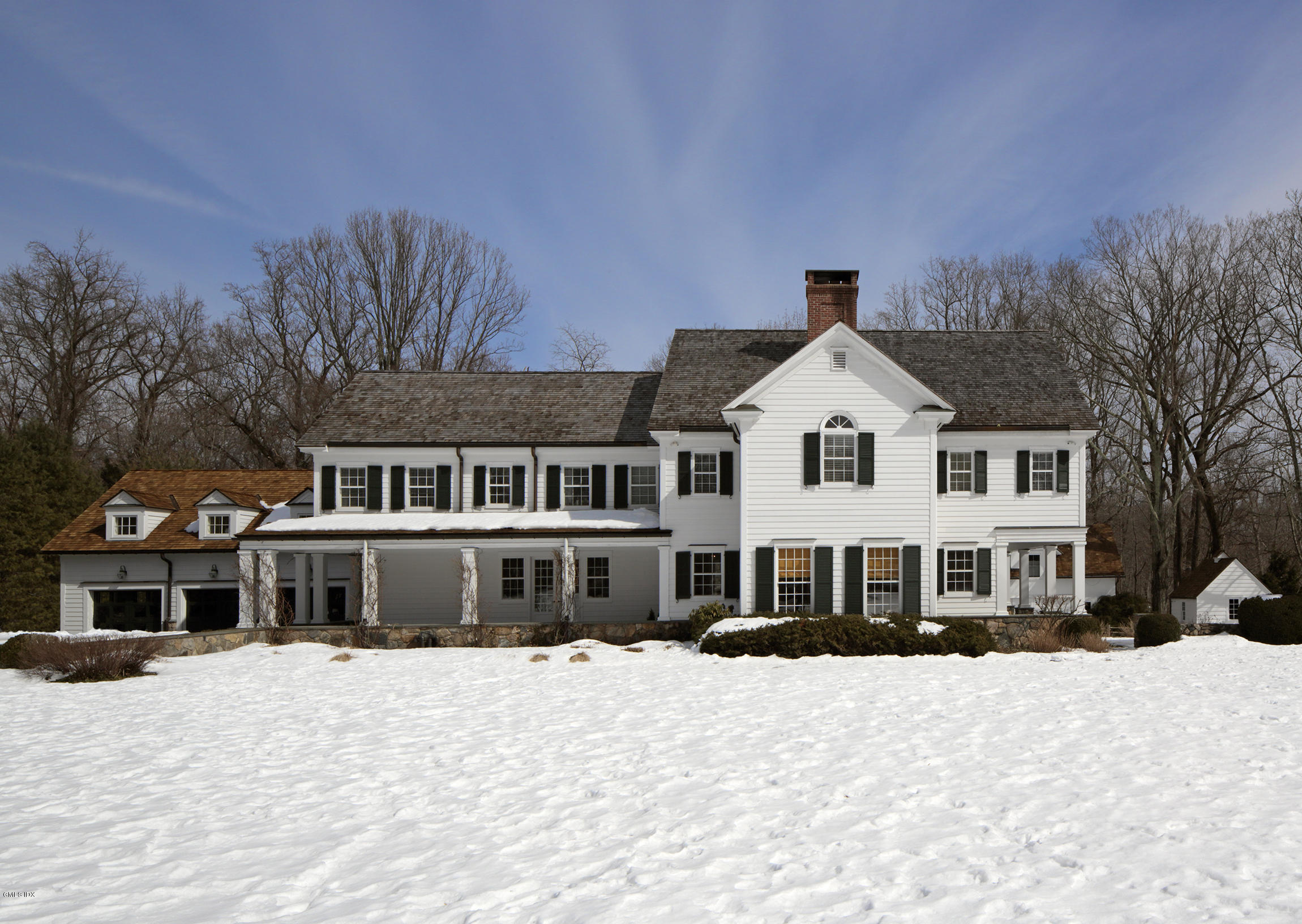 a front view of a house with a yard covered in snow