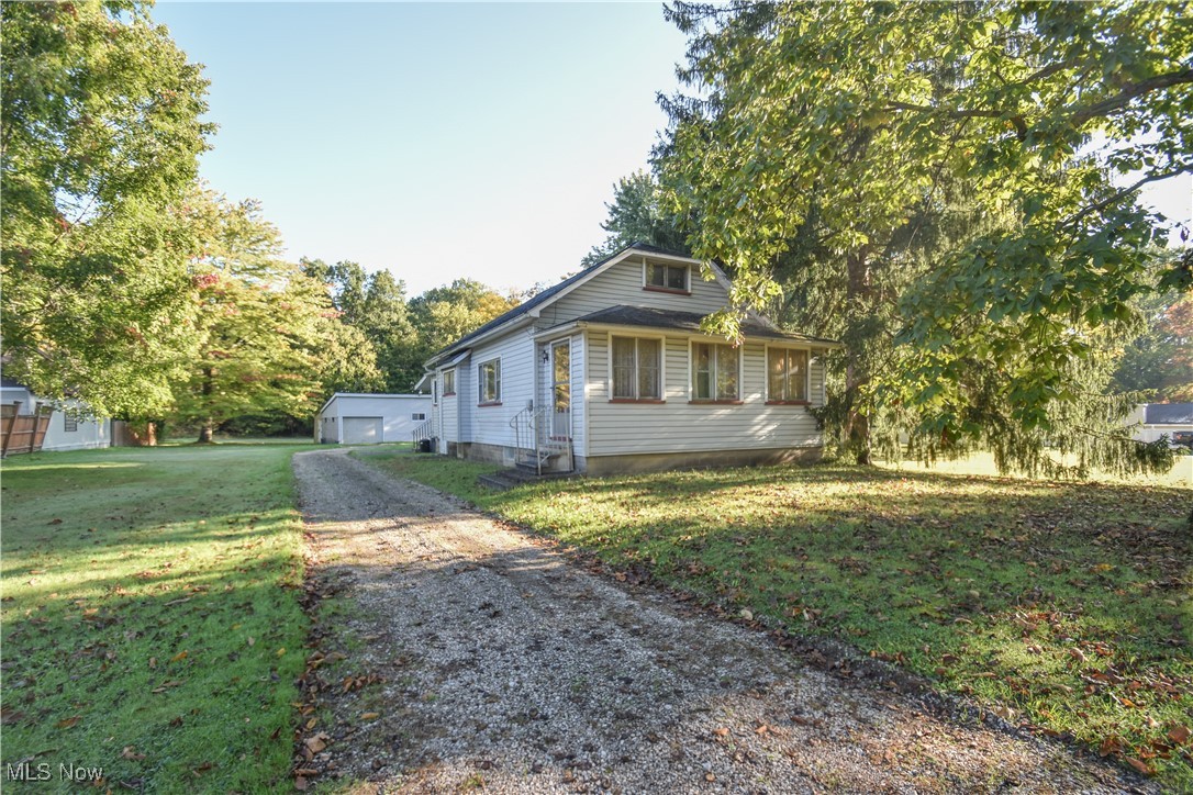 5382 West Webb Road Youngstown, OH 44515 - Photo 22 of 50 View of front facade featuring a garage and a front lawn