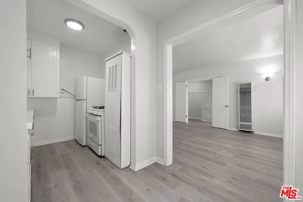 a view of a kitchen with a refrigerator and wooden floor