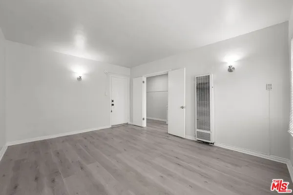 a view of an empty room with wooden floor