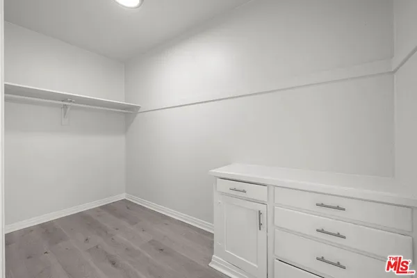 a view of a storage and utility room with wooden floor