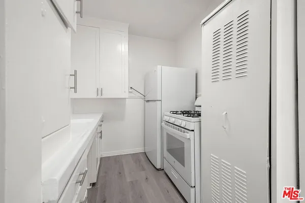 a kitchen with a stove top oven and cabinets