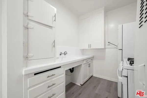 a kitchen with a sink cabinets and wooden floor