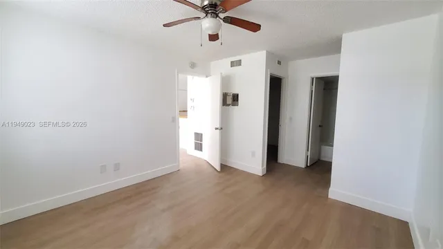 wooden floor in an empty room with a ceiling fan