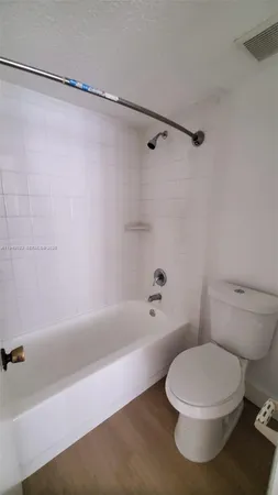 a white toilet and tub sitting next to a bathroom sink
