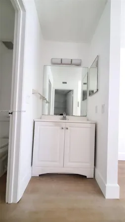 a view of a room with a sink and mirror