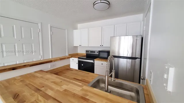 a kitchen with granite countertop a refrigerator and a sink