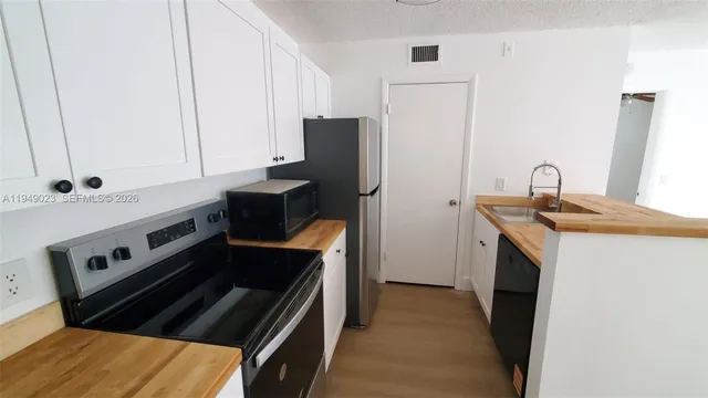 a kitchen with granite countertop a stove and a refrigerator